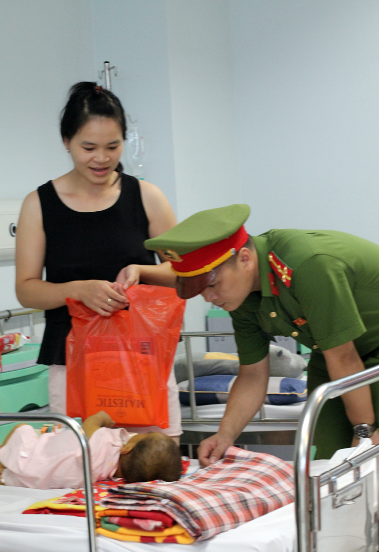 Cán bộ, chiến sĩ tới động viên, thăm hỏi và tặng quà các gia đình có bệnh nhi nhỏ.